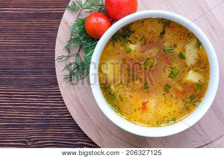 White soup noodles with tomatoes. Potatoes, dill, spices. On a wooden Board.