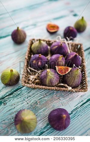 Ripe figs in a basket on a wooden table.
