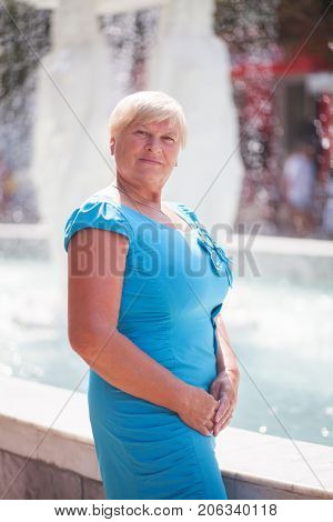 An elegant elderly woman posing outdoors. Portrait.