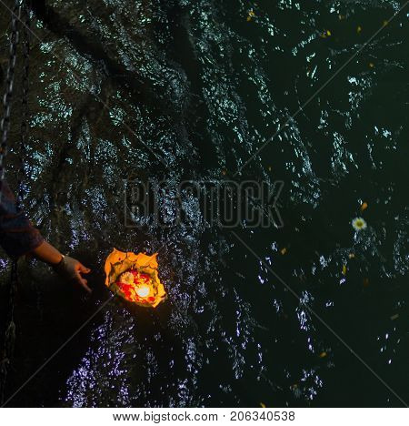 Holy ghats at Haridwar India sacred town for Hindu religion. Pilgrims offering floating flowers and burning candles to the Ganges River.