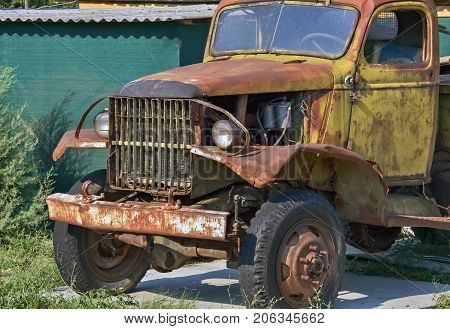 Front part of an old-fashioned rotting truck in the yard