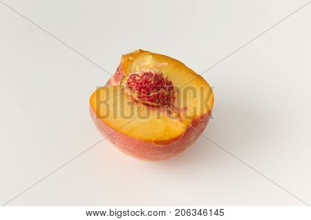 Fresh dissected peach with stone on white background