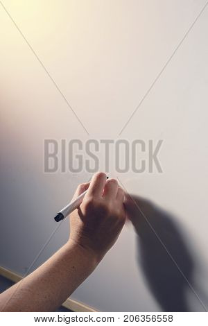 Hand writing on whiteboard surface - office business and education concept