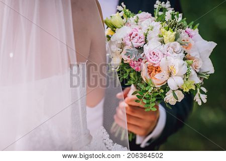 Wedding flowers bouquet and buttoniere in bride and groom hand