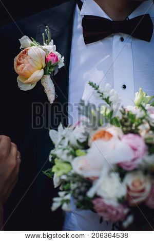 Wedding flowers bouquet and buttoniere in bride and groom hand
