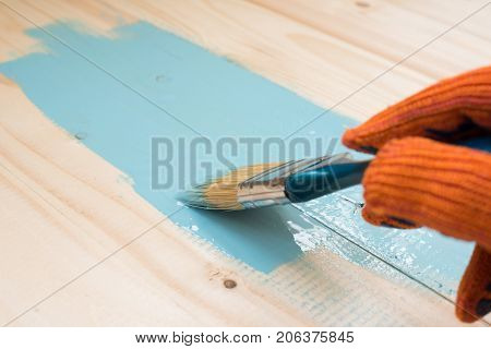 worker paints board. the employee paints the a wooden table. worker paints wooden board. wooden background with copy space