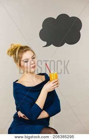 Woman holding fresh orange grapefruit juice. Healthy fruit drink smoothies concept black thinking or speech bubble next to her.