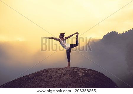 Asian women relax in the holiday. Play if yoga. On the Moutain rock cliff