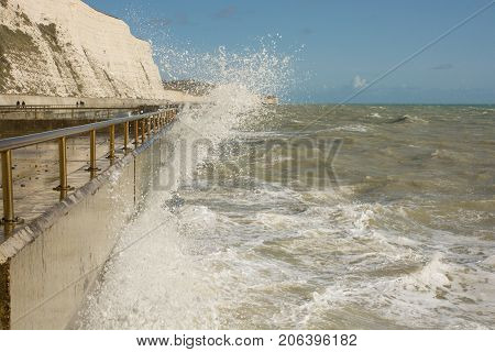 Rough sea with waves crashing onto seafront promenade at Rottingdean near Brighton East Sussex England
