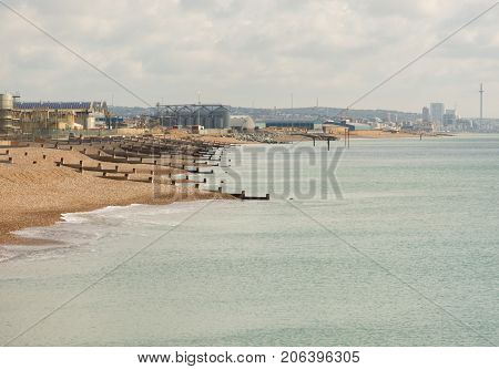 Seafront at Shoreham in West Sussex England with industrial units on harbour and port complex. Brighton in distance.