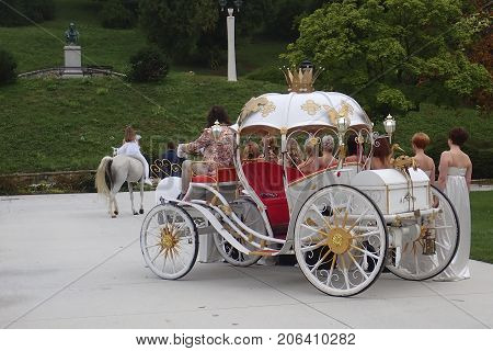 Princess riding a white horse and a coach with a retinue