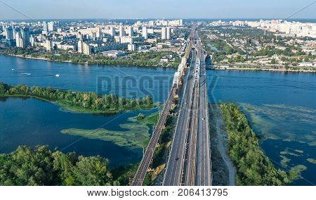 Aerial top view of Darnitsky bridge, Dnieper river and cityscape from above, city of Kiev, Ukraine