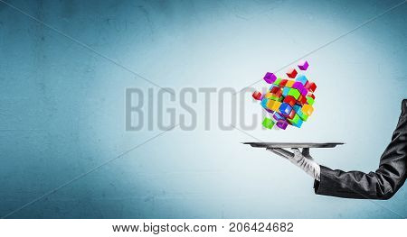 Cropped image of waiter's hand in white glove presenting multiple cubes on metal tray with blue background. 3D rendering.