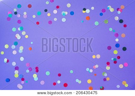 Festive party or carnival confetti on a purple background with copy space