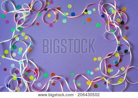 Festive party or carnival confetti on a purple background with copy space