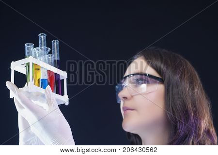 Medicine and Science Concepts. Caucasian Female Laboratory Assistant Examining Colorful Chemicals in Laboratory. Horizontal Image Composition