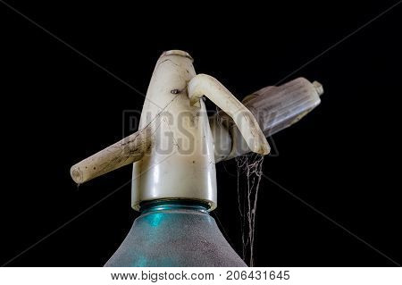 Old Dusty Siphon On Black Background. The Cobwebs Entwining The Old Siphon Into Soda Water.