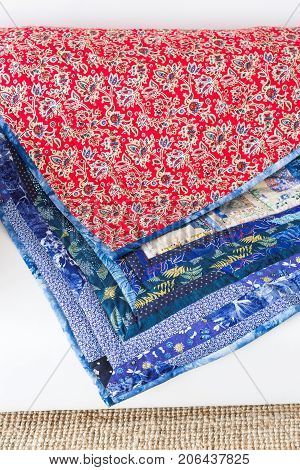 quilting, piecework, homemade, culture, interior, needlework concept - two blankets made in russian technique patchwork with contrast red and blue ornate material