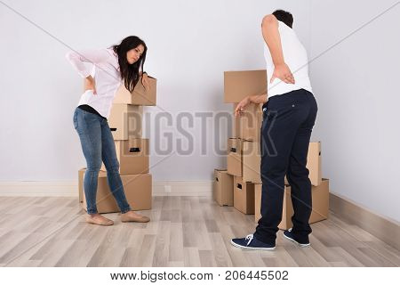 Young Couple Have Backpain While Moving The Boxes In Apartment