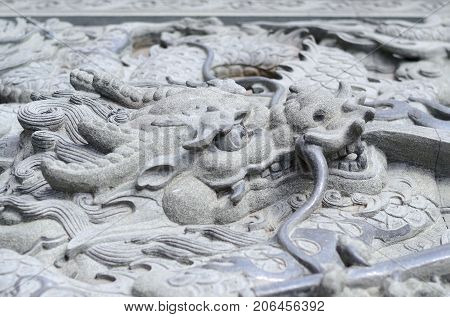 The gabel end of an Asian designed building with a dragon statue