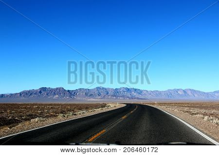 Road in the Death Valley National Park with blue sky background, California.