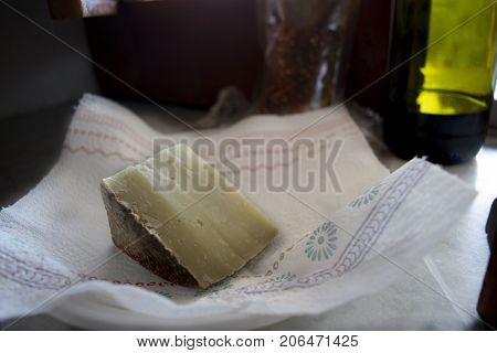 wedge of sardinian pecorinowith in background a bottle of red wine