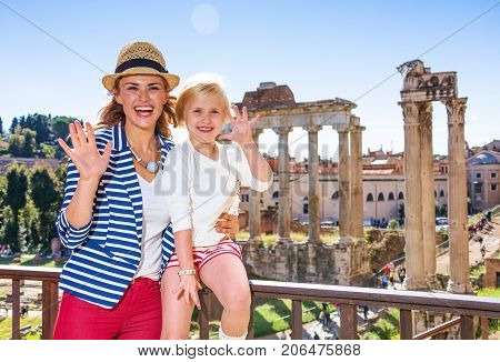 Smiling Mother And Child Tourists Near Roman Forum Handwaving