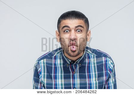 Comic Faces Concept. Funny Hipster Showing Stupid Face And Looking At Camera.