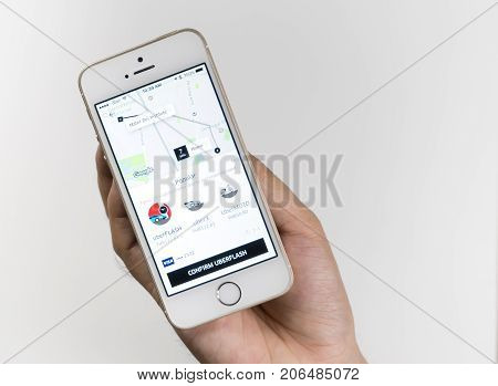 Bangkok Thailand - September 28 2017: Business Man is using Uber application on his iPhone.