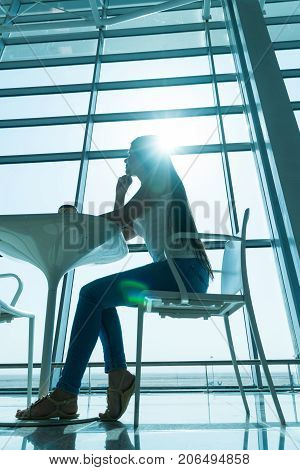 Girl Is Holding A Glass Of Coffee In Airport's Business Lounge With Aircraft