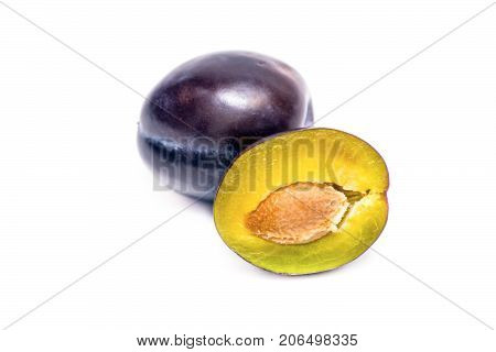 whole plum and half a plum on a white background