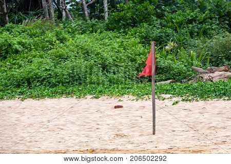 Red warning flag on beach showing that swimming is dangerous or prohibited