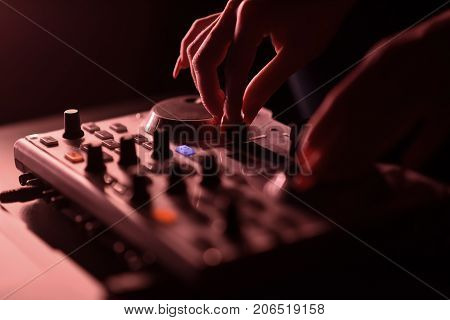 DJ mixer disco illuminated by floodlights at the club