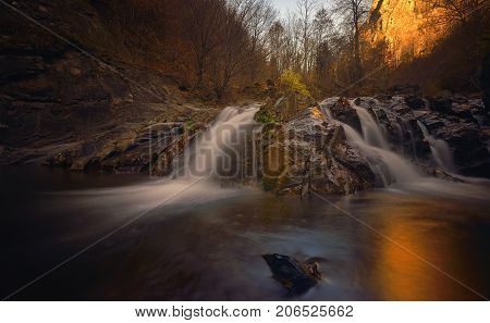Autumn landscape with trees and river, in sunset
