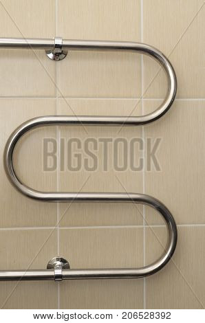 Metal Curved Coil In The Bathroom With Ceramic Tiles