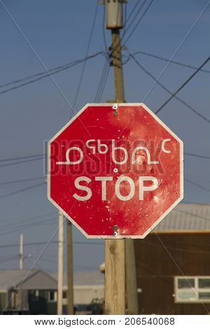 Multilingual road traffic stop sign in Inuktitut (Syllabic), English and French