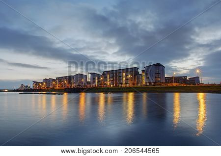 Dockland Apartment Building at dusk with reflections in the water.