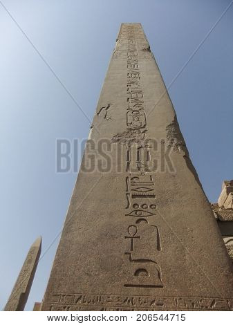 Obelisk at Karnak with hieroglyphics in vertical format against a blue sky