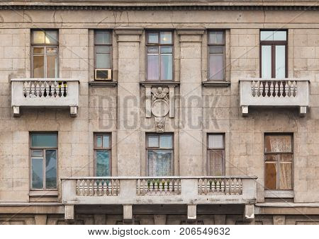 Several windows and balconies in a row on facade of urban apartment building front view St. Petersburg Russia