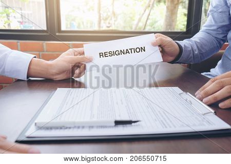 Close up of the hand employer filing final remuneration after employee to write a document letter of resignation resign concept.