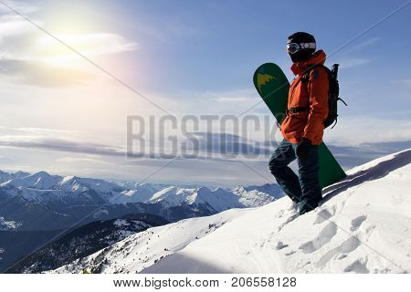 Small snowboarder on blue sky backdrop. Snowboarding space for text concept