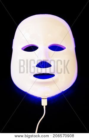 Light rejuvenating mask for facial skin therapy on black background