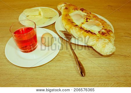 Adjarian khachapuri on a on a plate. Open pie with cheese in the shape of the boat. Delicious homemade khachapuri in Adjarian - Retro color