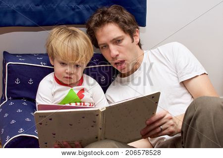 Father Reading Bedtime Storytime To Toddler Son