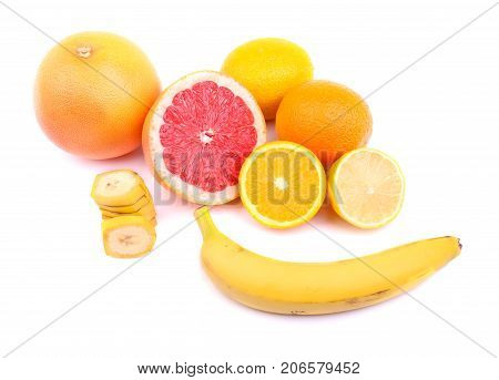 Vivid juicy lemons, grapefruit, oranges, slices of bananas and whole banana, round citruses with an acid and sweet, juicy pulp, vegetables full of vitamins for health isolated on a white background.