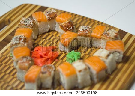 The unagi and philadelphia rolls in the shape of heart on a bamboo board