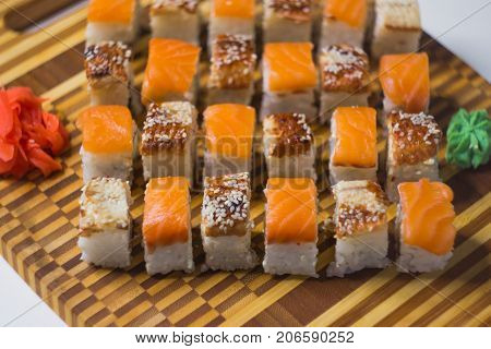 The set of rolls with ginger and wassabi on bamboo board