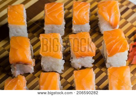 The set of salmon rolls on bamboo board. Focus on middle line