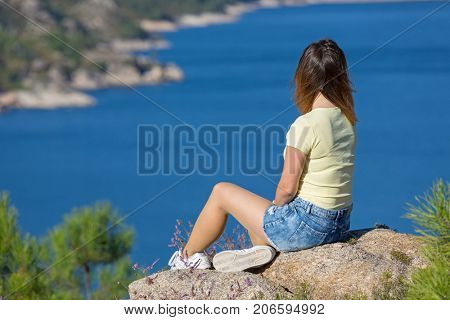 Young happy woman at the mountain, relaxing and enjoying the lake at Geres, Portuguese National Park