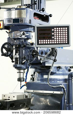 drill machine stand in garage or workshop. Machine controlled by automation and programmable. Technician use the machine for drilling the object or structure.